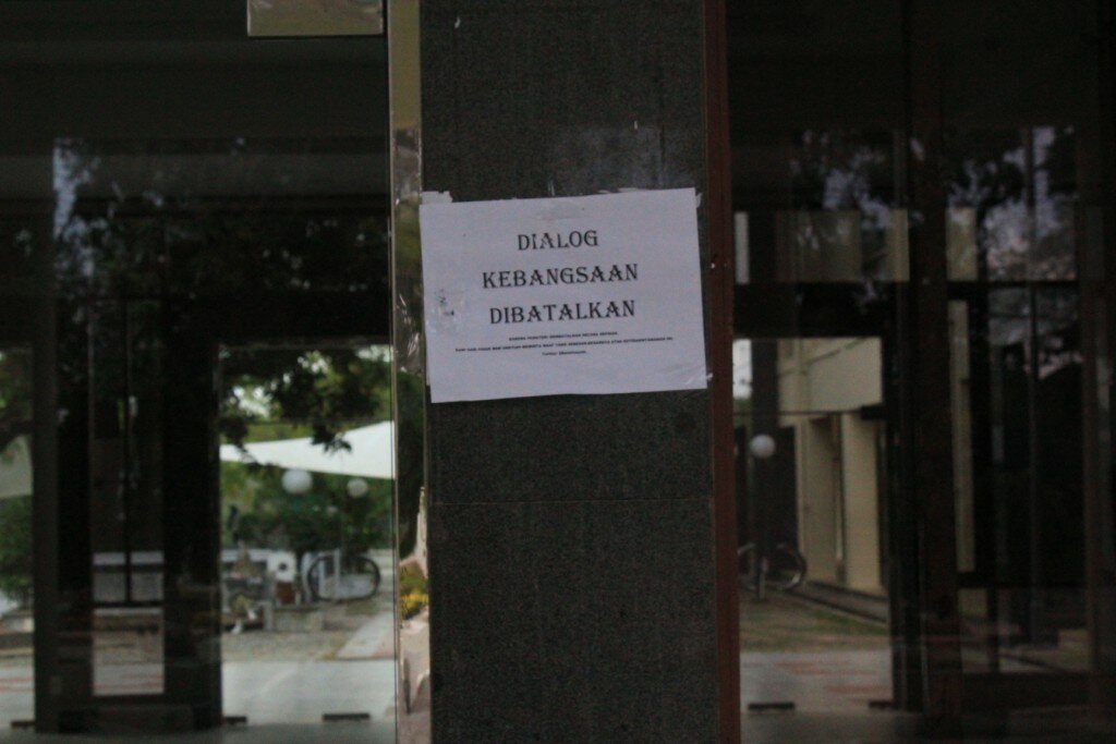 Foto 3 : Beberapa selebaran kertas yang bertuliskan “dialog kebangsaan dibatalkan” tertempel didepan pintu masuk gedung AAC. ( Tajul Ula-DETaK)